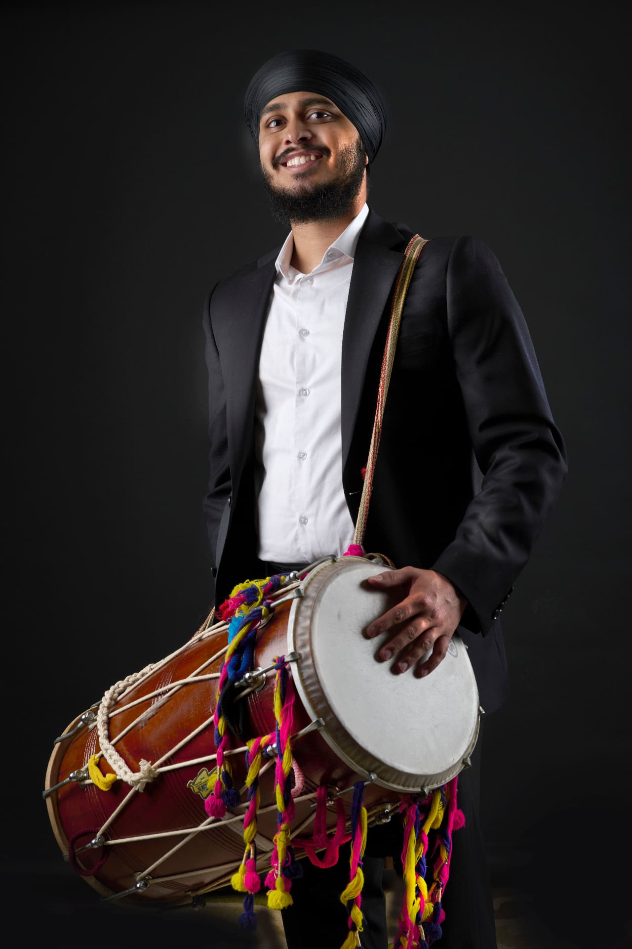 Live dhol performer mid-strike during a baraat